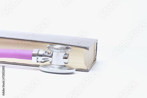 A medical stethoscope near a book