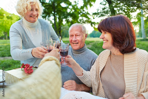 Senioren stoßen mit Wein zum Geburtstag an