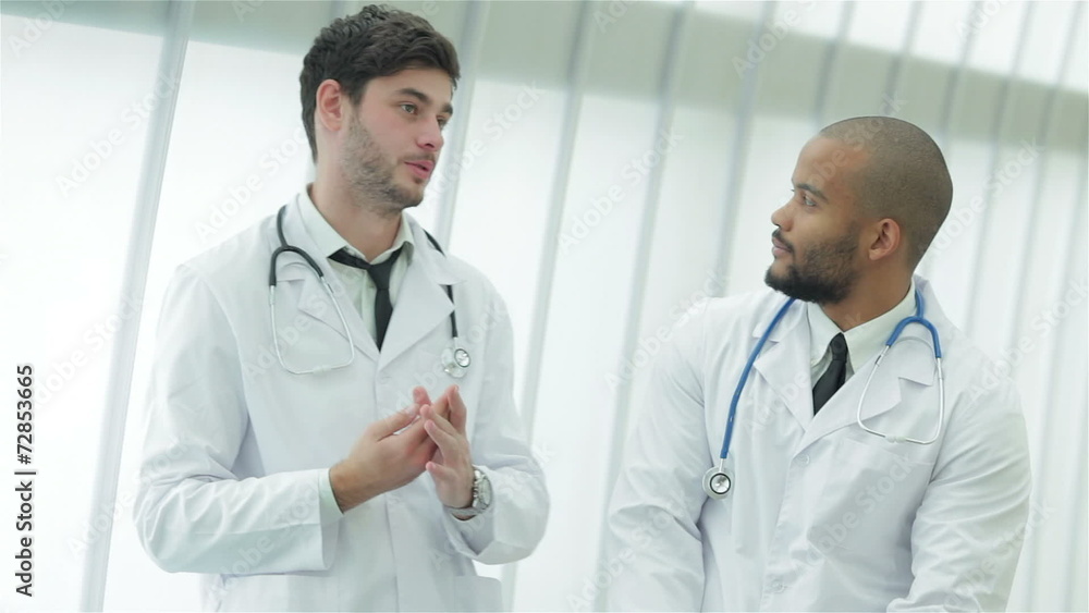 Two young doctors in medical gown lively debating Two young doctors in medical gown lively debating