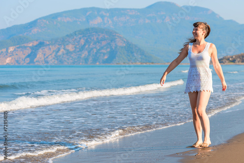 Happy girl walking barefoot on the beach © kosmos111