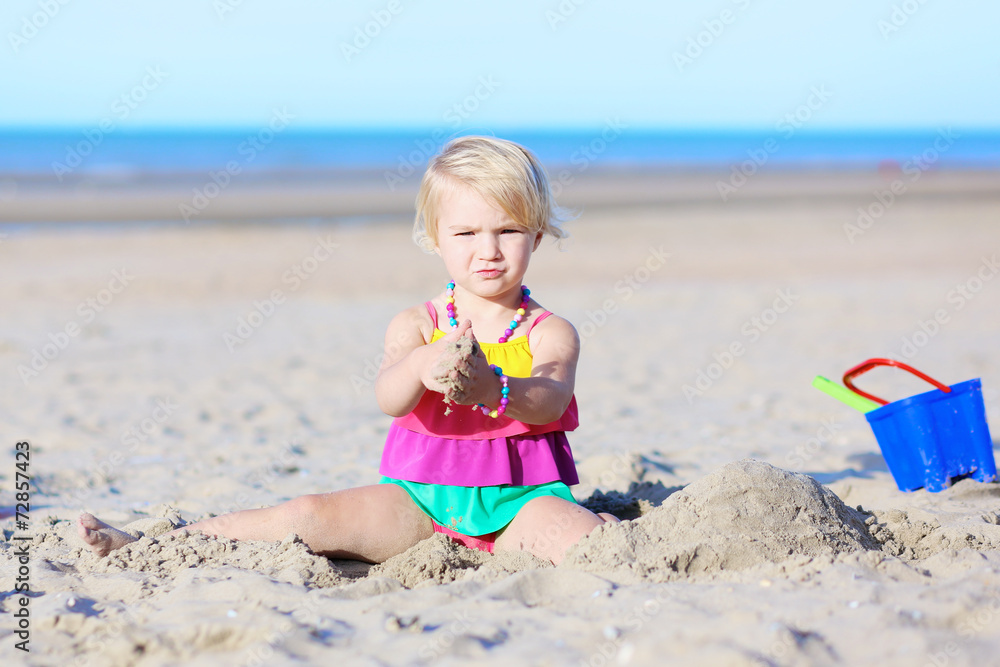 Little happy girl having fun playing on the beach Little happy girl having fun playing on the beach