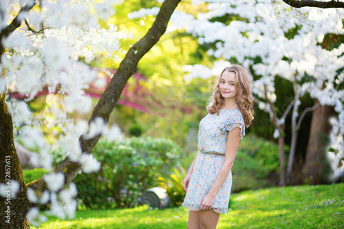 Beautiful young girl in cherry garden