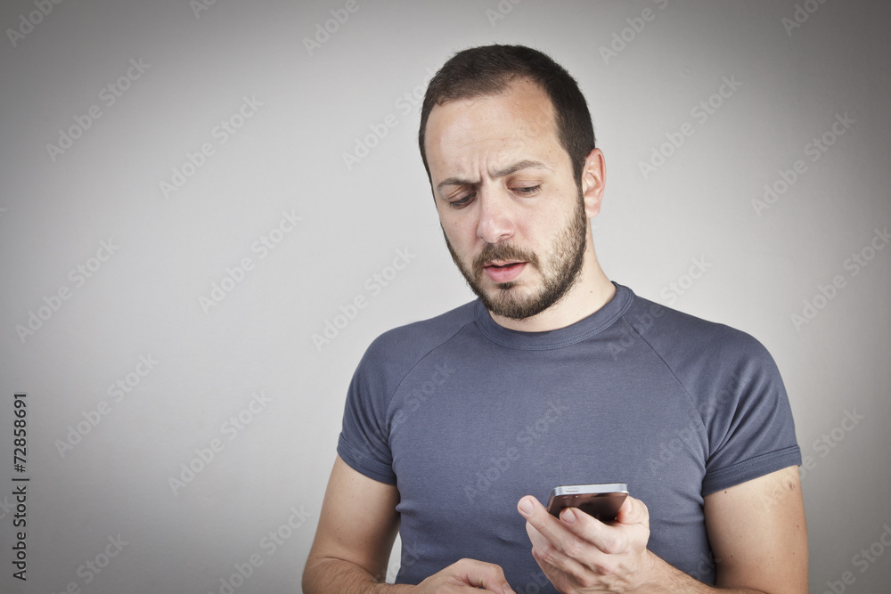 Happy young man gesturing while answering smart phone Happy young man gesturing while answering smart phone