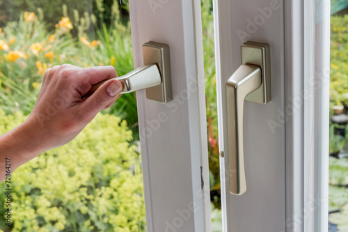 Frau öffnet Fenster zum Lüften photo