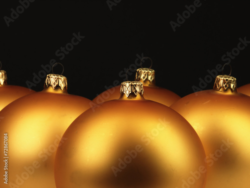 Big golden Christmas balls on black background.