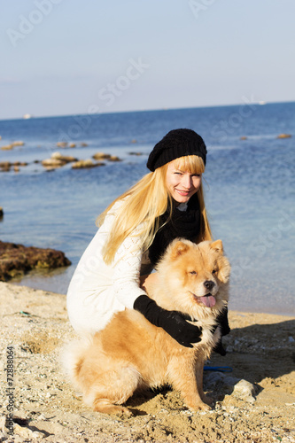 Attractive girl with her dog wearing warm clothes