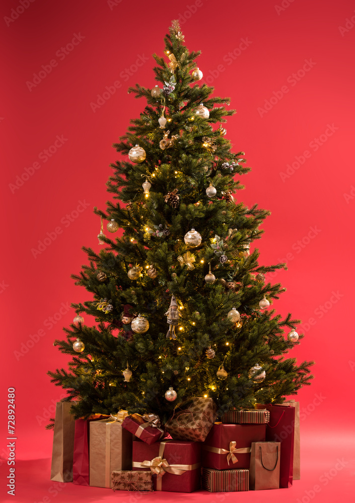 Christmas tree with gifts on red background full length - obrazy, fototapety, plakaty 