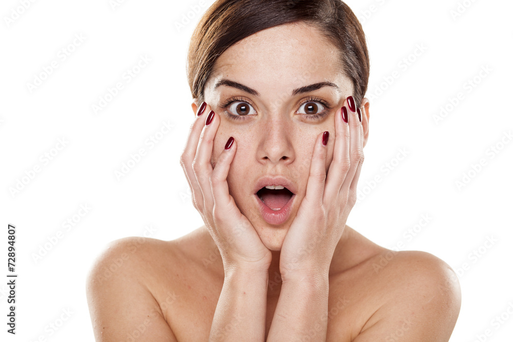shocked young woman without make-up on a white background shocked young woman without make-up on a white background