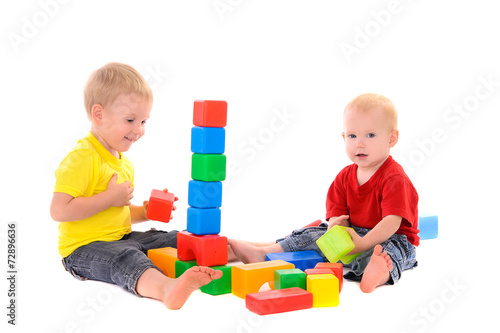 two brothers build toy building of colored cubes