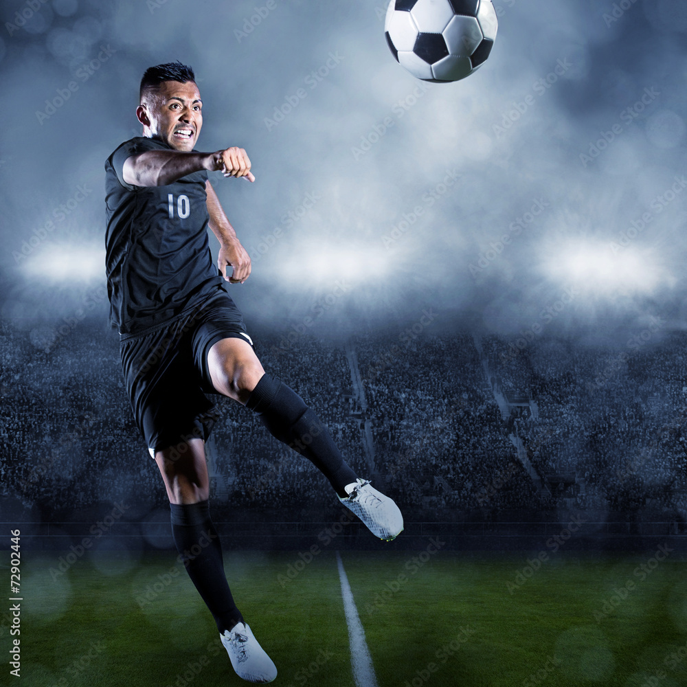 Naklejka premium Soccer player kicking ball in a large stadium