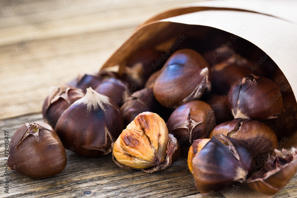 Delicious roasted chestnuts on wooden board Delicious roasted chestnuts on wooden board