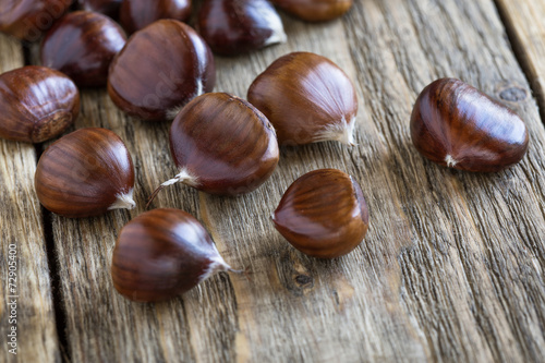 Raw chestnuts on wooden board