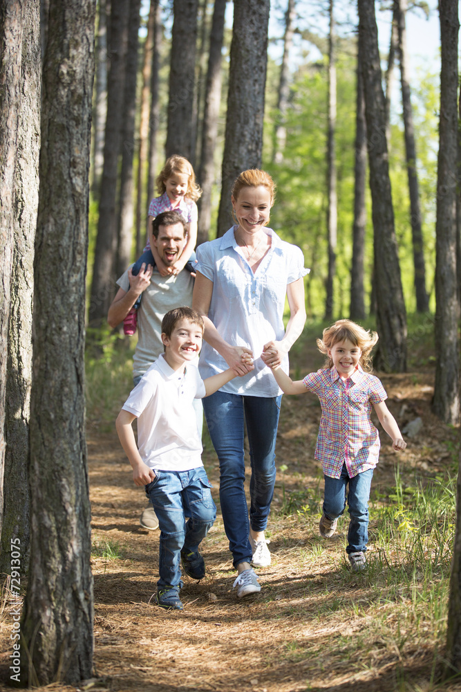 Familie geht mit Kindern im Wald spazieren Familie geht mit Kindern im Wald spazieren