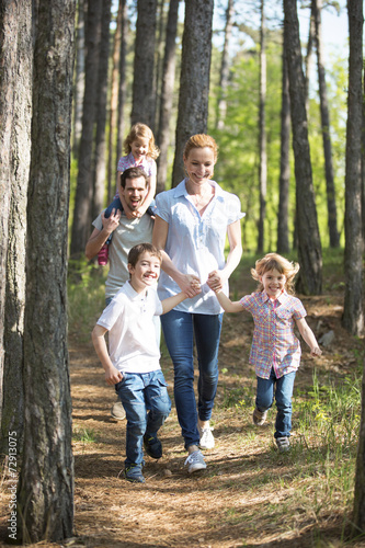 Familie geht mit Kindern im Wald spazieren