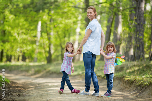 Mutter mit Zwillingen geht im Wald spazieren