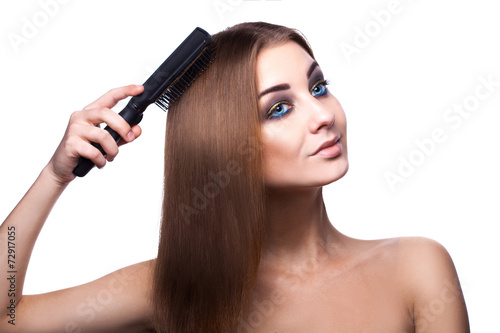 Voluptuous girl with blue eyes combing her perfect healthy strei