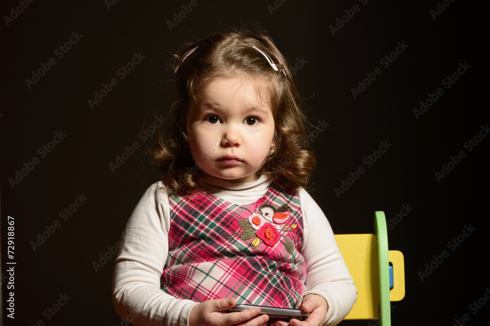 Close up portrait of a little girl sitting on a chair Close up portrait of a little girl sitting on a chair