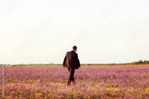 bride and groom love in a mouve flower land on sunset © hreniuca