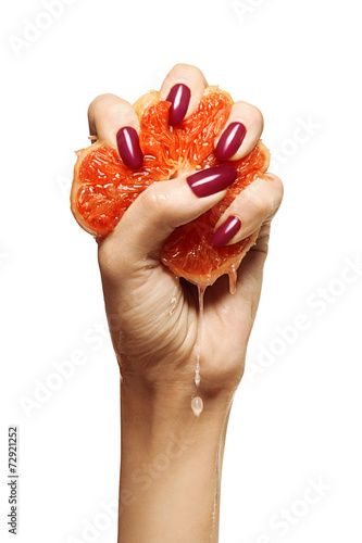 Billede på lærred beauty female with purple nails squeezing grapefruit isolated