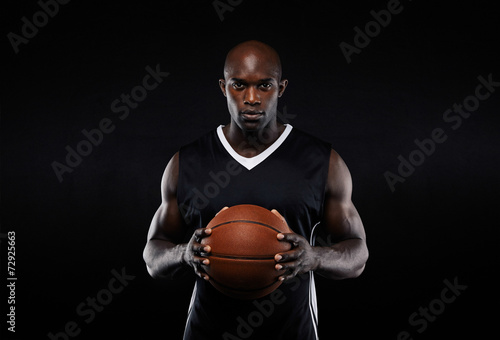 Muscular young male basketball player in uniform photo