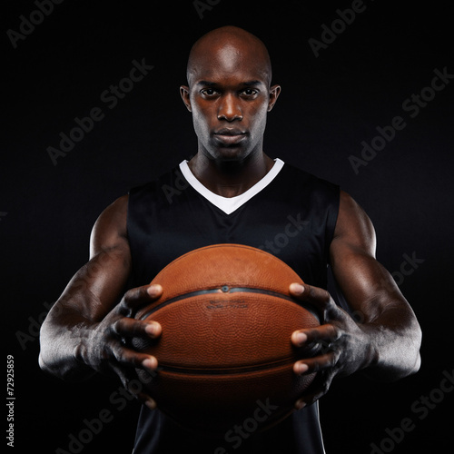 Muscular young basketball player with a ball