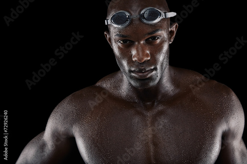 Fit young swimmer on black background