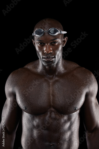 Professional male swimmer on black background
