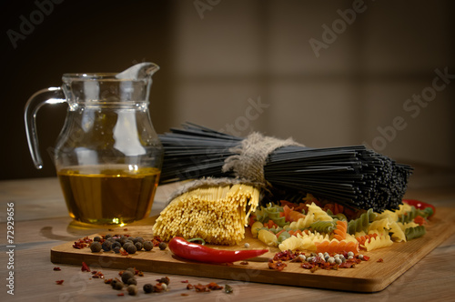 Different kinds of pasta on the wooden background. photo