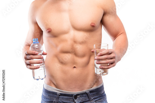 Muscular man torso with bottle and water