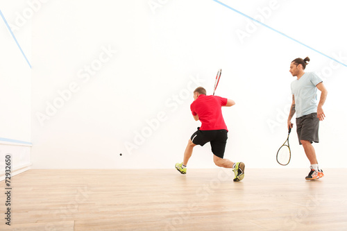 Two men playing match of squash.