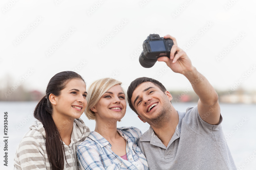 Portrait of happy friends taking photo of themselves on beach. Portrait of happy friends taking photo of themselves on beach.