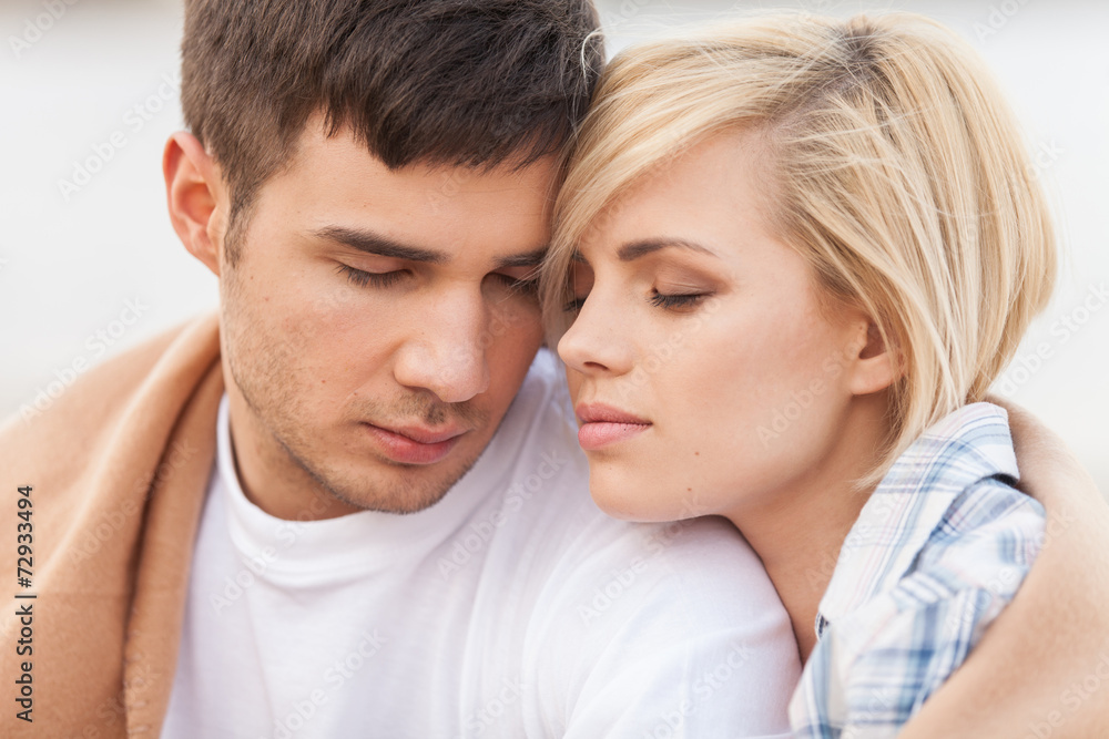 Attractive young couple standing on beach at summer. Attractive young couple standing on beach at summer.