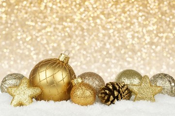 Gold Christmas ornament border in snow with gold background