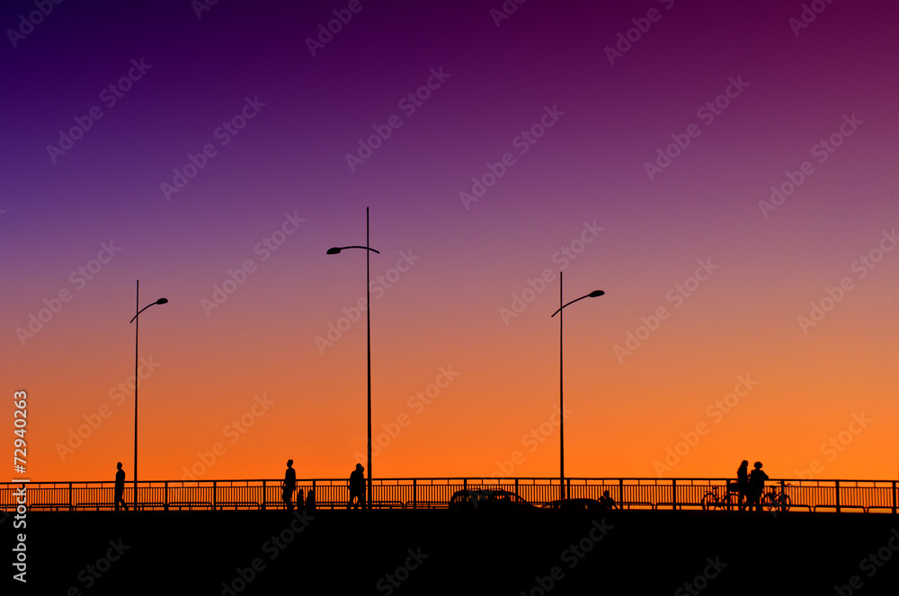 People on the bridge in sunset