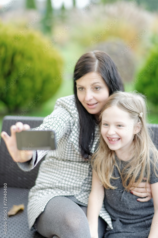 Mother and daughter sitting in nature and talking selfie Mother and daughter sitting in nature and talking selfie
