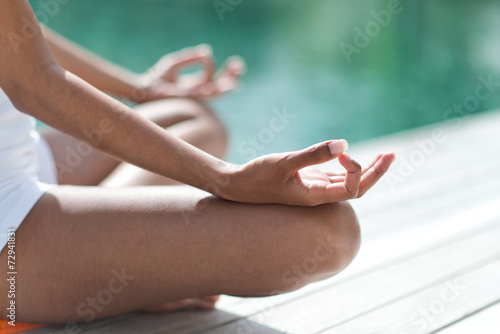 Billede på lærred Woman sitting on a wooden deck meditating