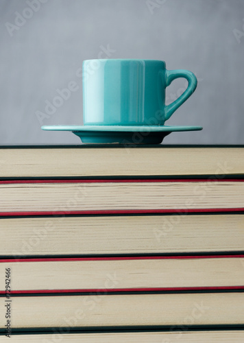 Blue coffee cup on stack of books