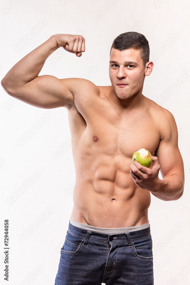 Muscular fitness man with apple showing biceps Muscular fitness man with apple showing biceps
