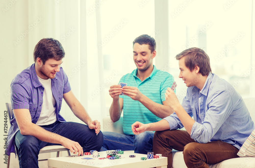 happy three male friends playing poker at home happy three male friends playing poker at home