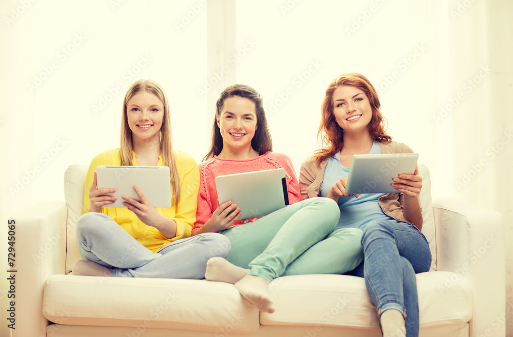 three smiling teenage girls with tablet pc at home three smiling teenage girls with tablet pc at home