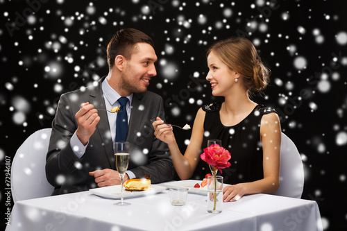 smiling couple eating dessert at restaurant