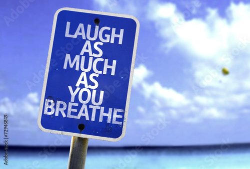 Laugh As Much As You Breathe sign with a beach on background