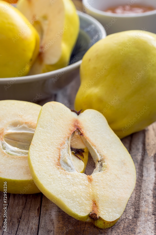 Quinces on a wooden background, sliced and whole.