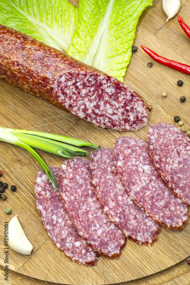 sausages on a wooden plate with vegetables in a restaurant sausages on a wooden plate with vegetables in a restaurant