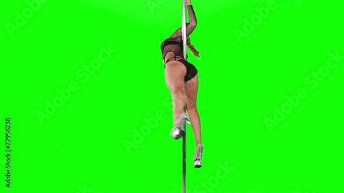 Young sexy woman exercise pole dance against a green screen