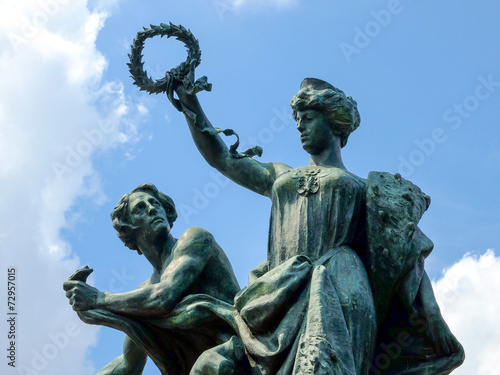 Classic bronze statue closeup with blue sky background