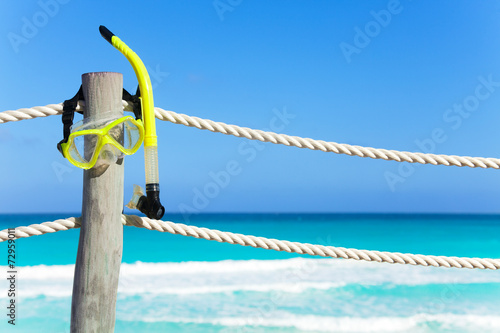 Snorkeling mask hanging on the wooden pier stake