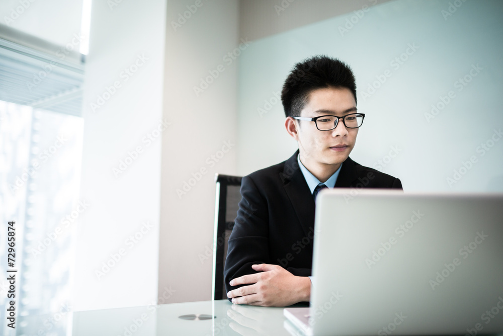 Young handsome man using laptop in his office Young handsome man using laptop in his office