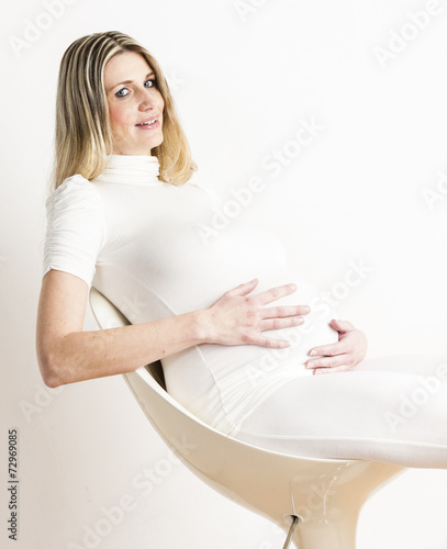 portrait of sitting pregnant woman wearing white clothes