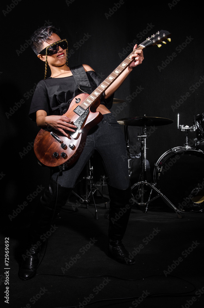 Young woman playing guitar during the concert